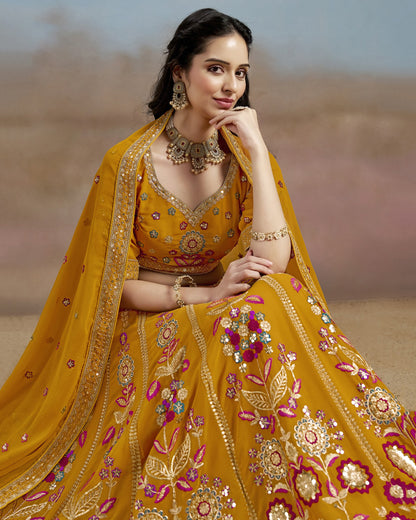 Woman in a traditional yellow embroidered outfit with jewelry against a blurred background