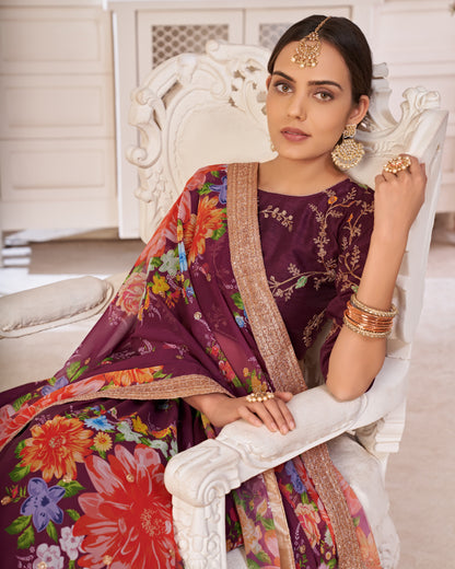 Woman in a traditional outfit with floral patterns sitting on a white chair.