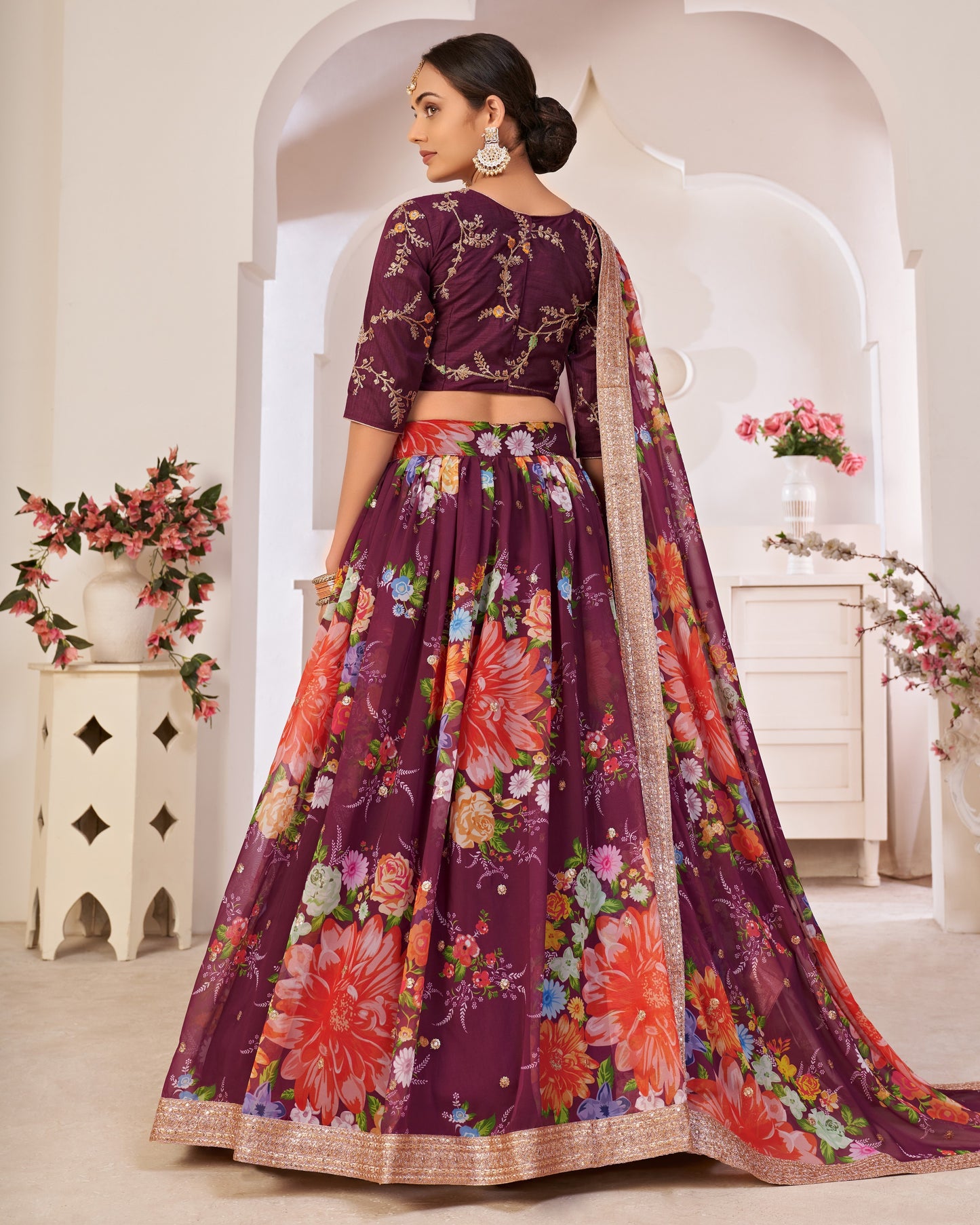 Woman wearing a floral purple lehenga with a white background