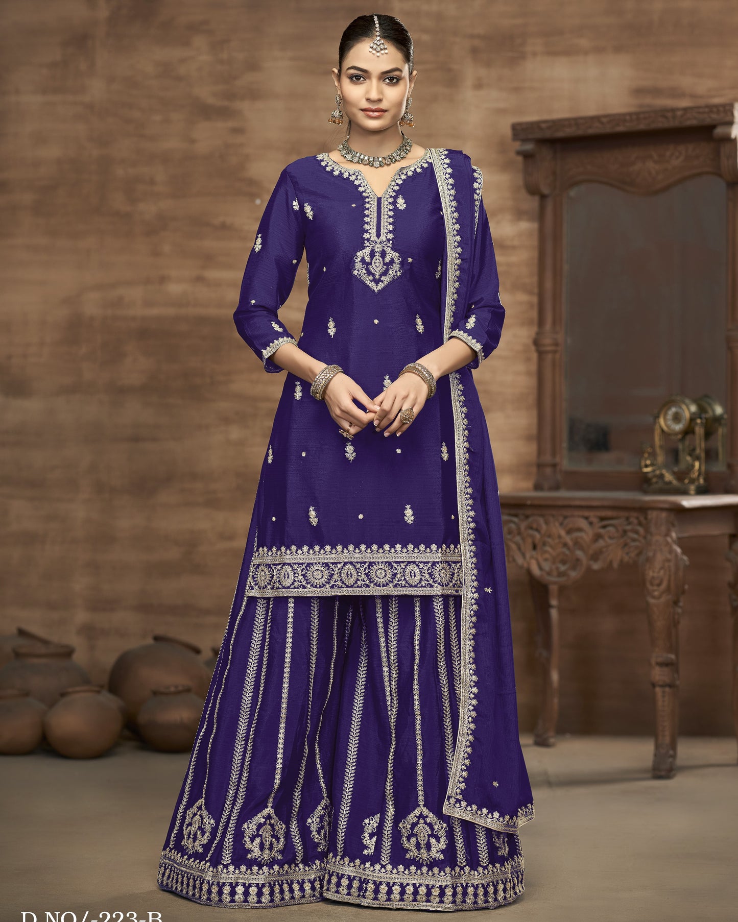 Woman wearing a traditional blue embroidered outfit with a wooden background