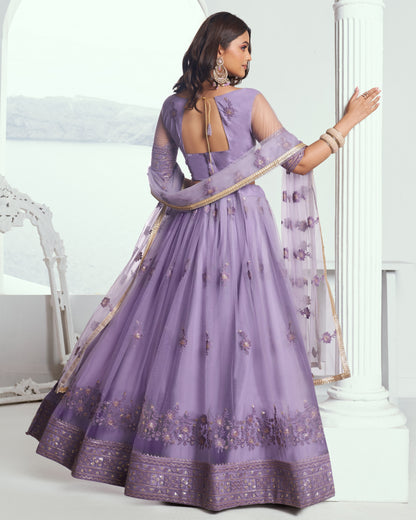 Woman wearing a purple embroidered saree with a white background