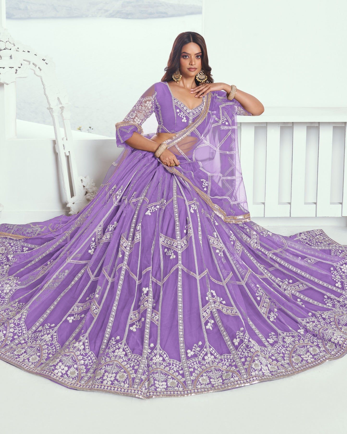 Woman wearing a purple embroidered saree with a white background