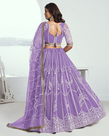 Woman wearing a purple embroidered lehenga with a white background