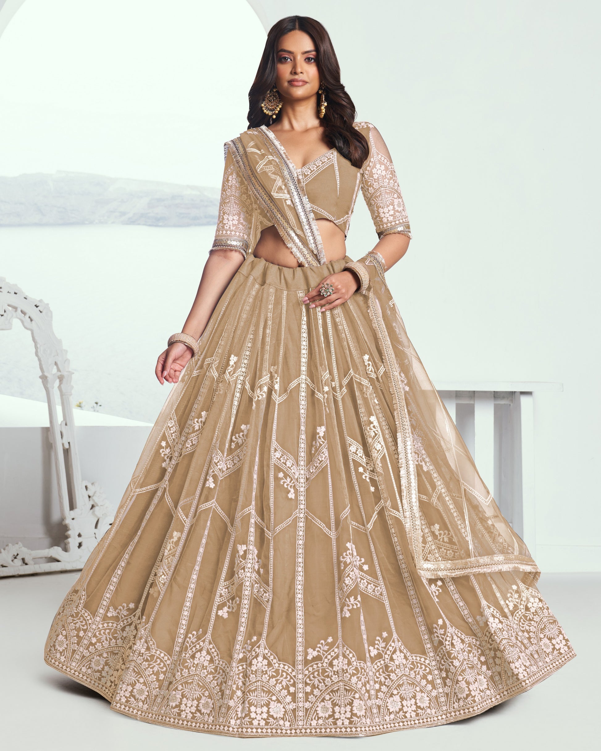 Woman wearing a beige embroidered traditional outfit on a white background