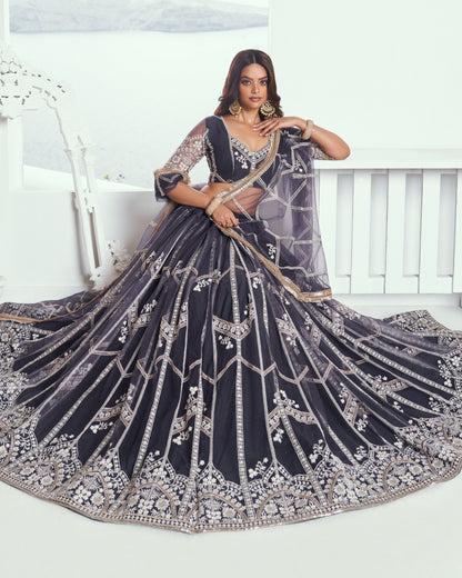 Woman in a dark blue embroidered lehenga with silver details on a white background