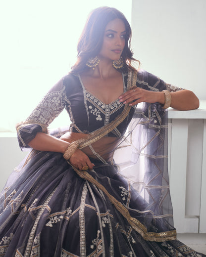 Woman in a black and gold traditional outfit with intricate designs.