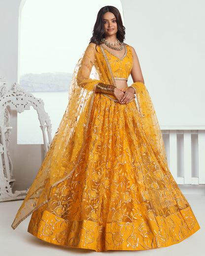 Woman wearing a yellow embroidered traditional outfit with a white background