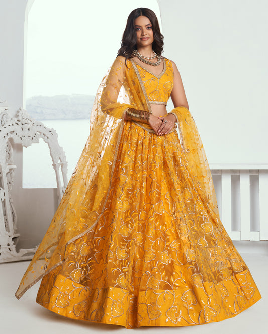 Woman wearing a yellow embroidered traditional outfit with a white background