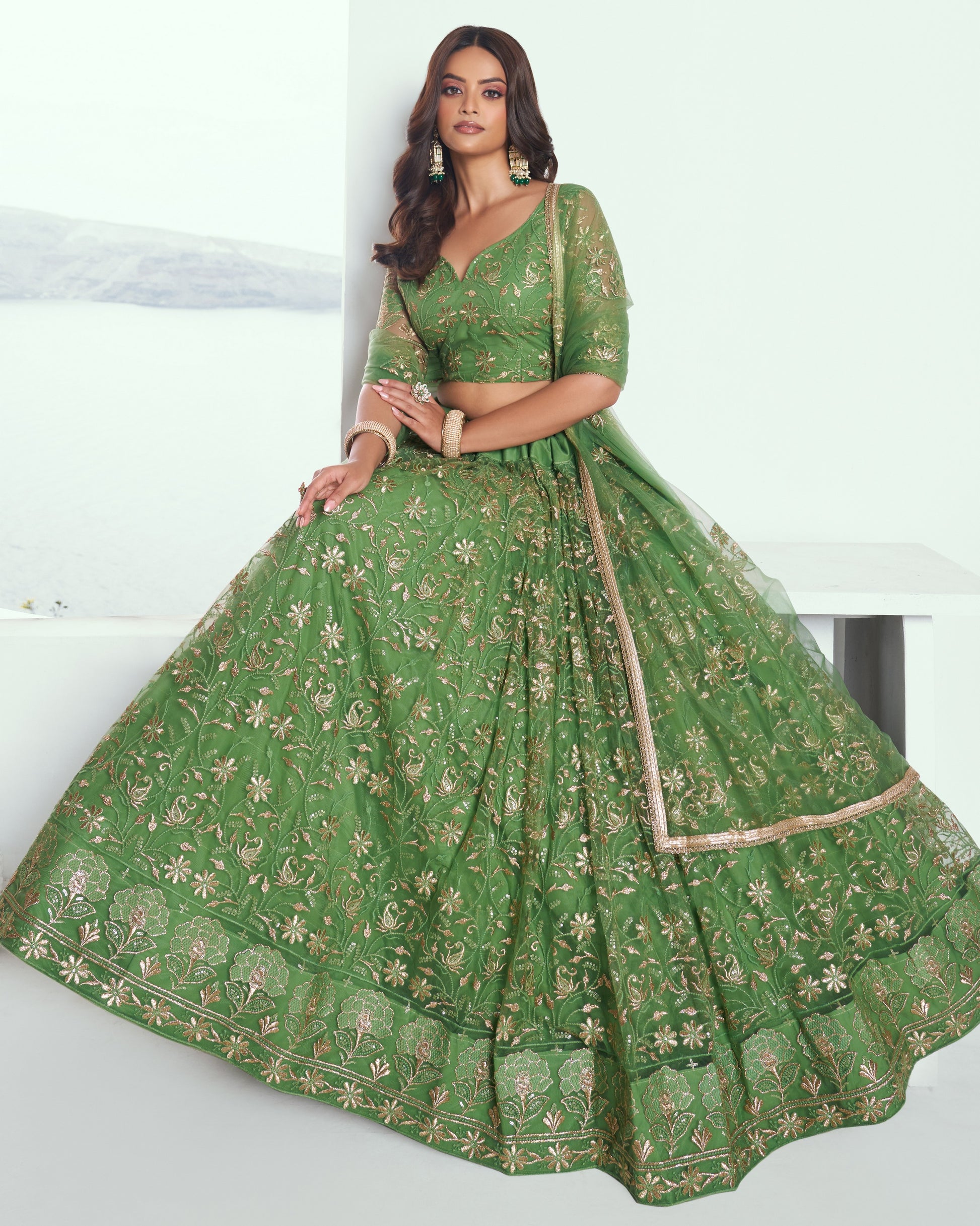 Woman wearing a green embroidered traditional outfit on a white background