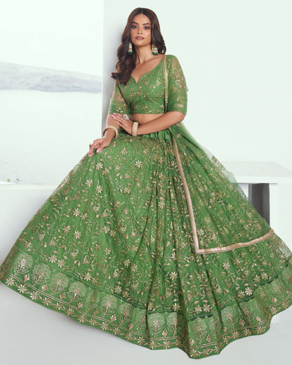 Woman wearing a green embroidered traditional outfit on a white background