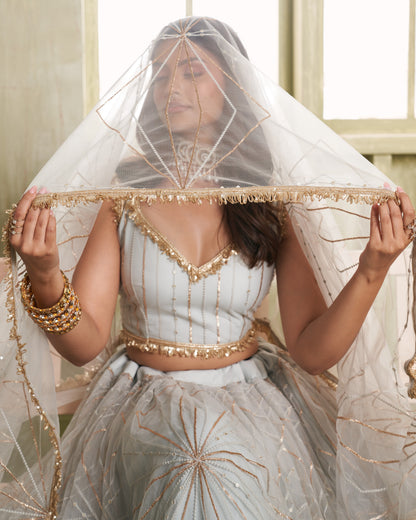 Woman wearing a traditional outfit with a decorative veil indoors