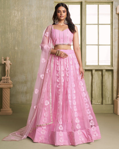 Woman wearing a pink embroidered lehenga in an indoor setting