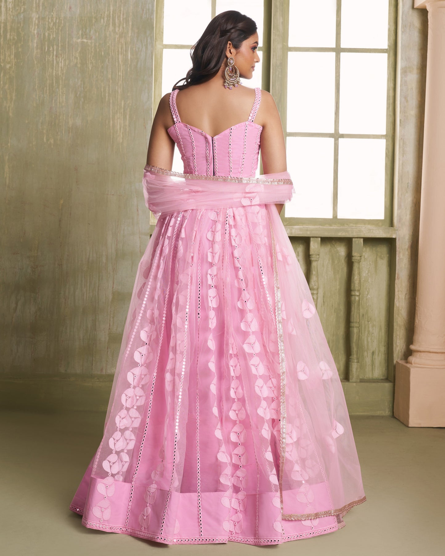 Pink evening gown with floral details on a neutral background