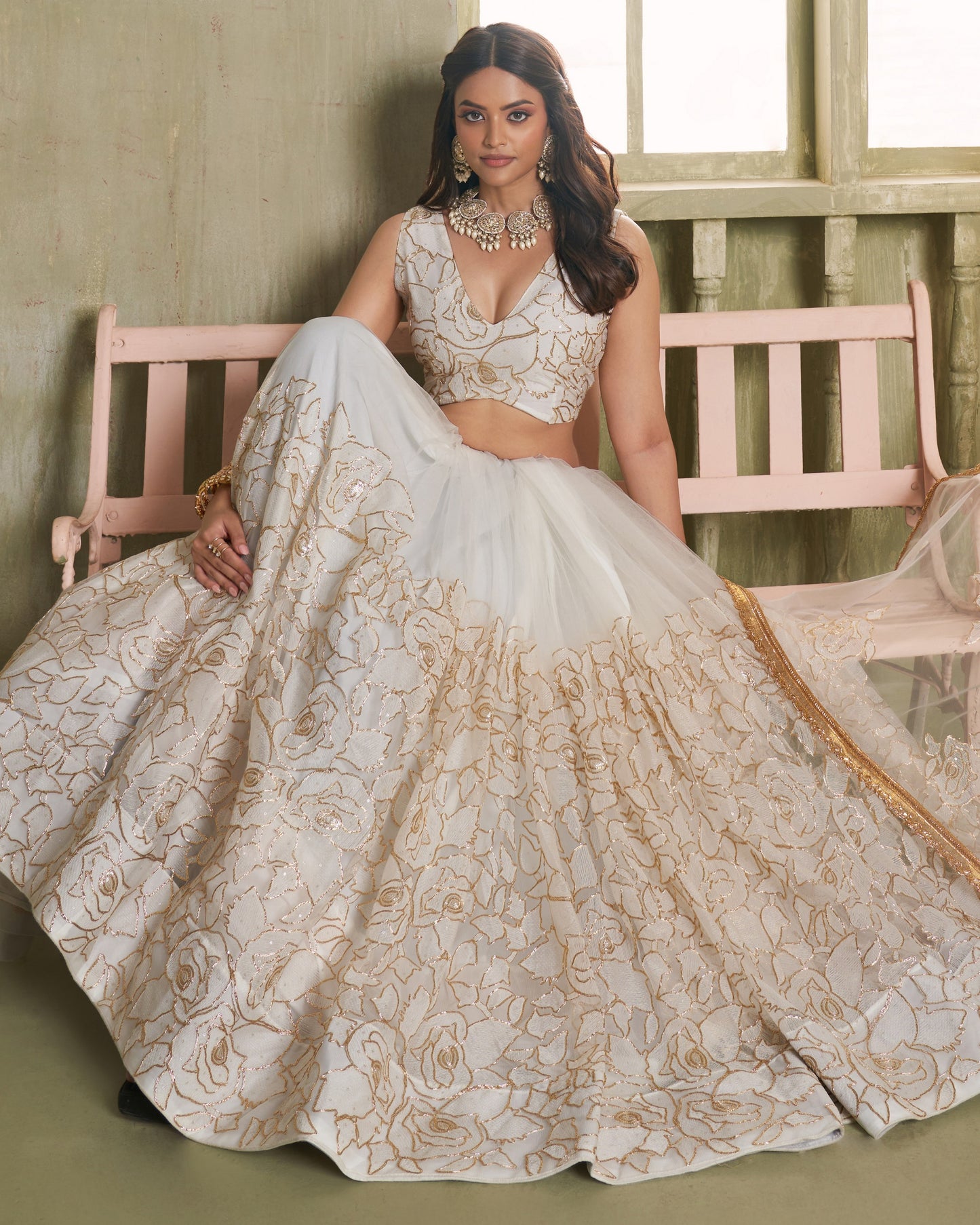 Woman in a traditional embroidered outfit sitting on a bench.