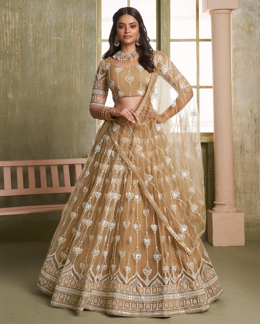 Woman wearing a beige embroidered lehenga in an indoor setting