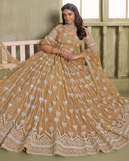 Woman in a beige embroidered traditional outfit sitting on a bench.