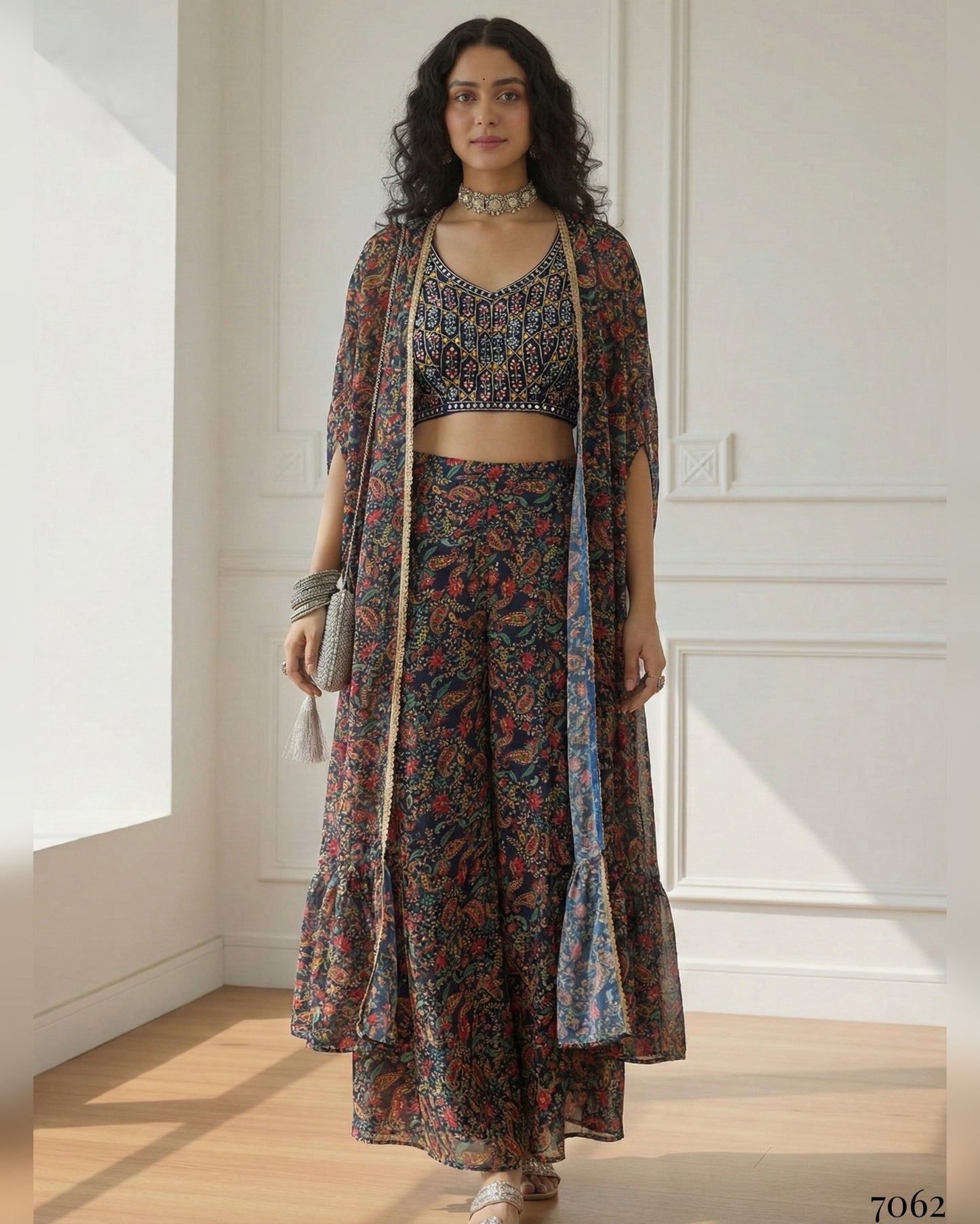 Woman wearing a patterned outfit with a long jacket in a bright room.