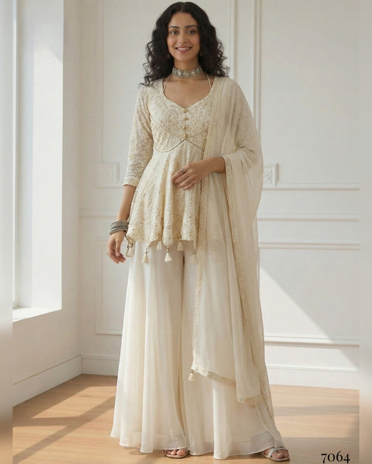 Woman wearing a beige traditional outfit with a matching dupatta in a bright room.