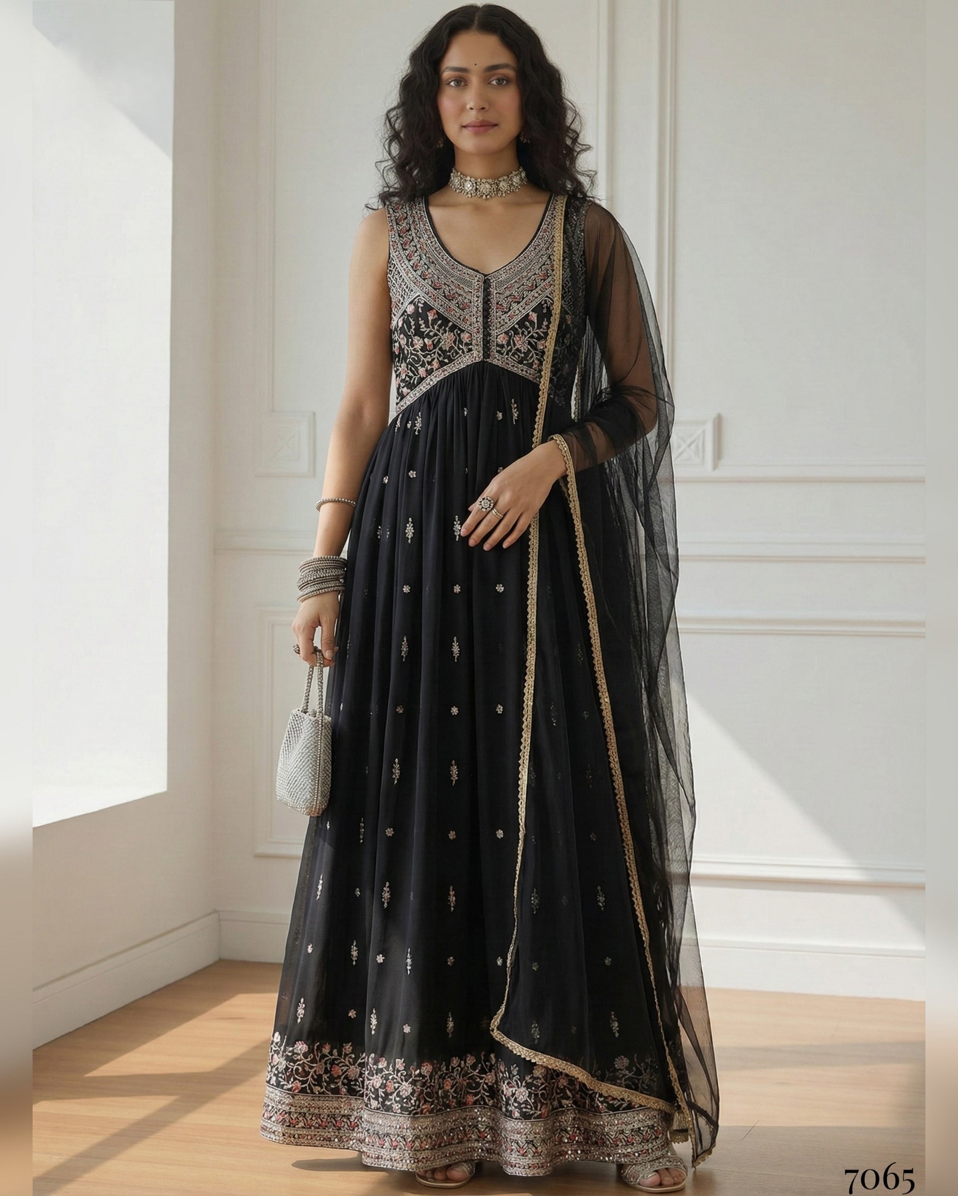 Woman wearing a black and silver embroidered dress in a bright room.