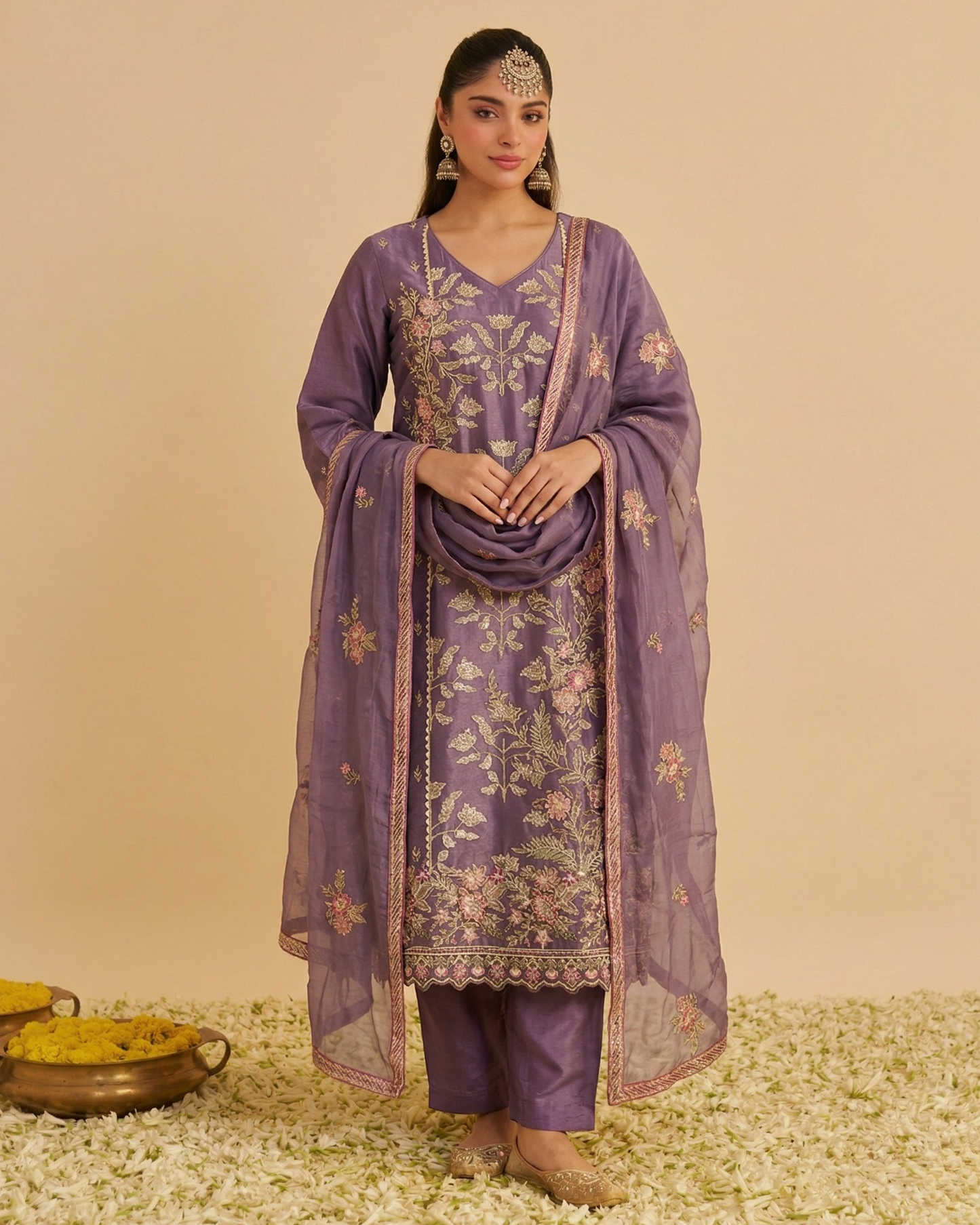 Woman wearing a purple embroidered traditional outfit with a beige background