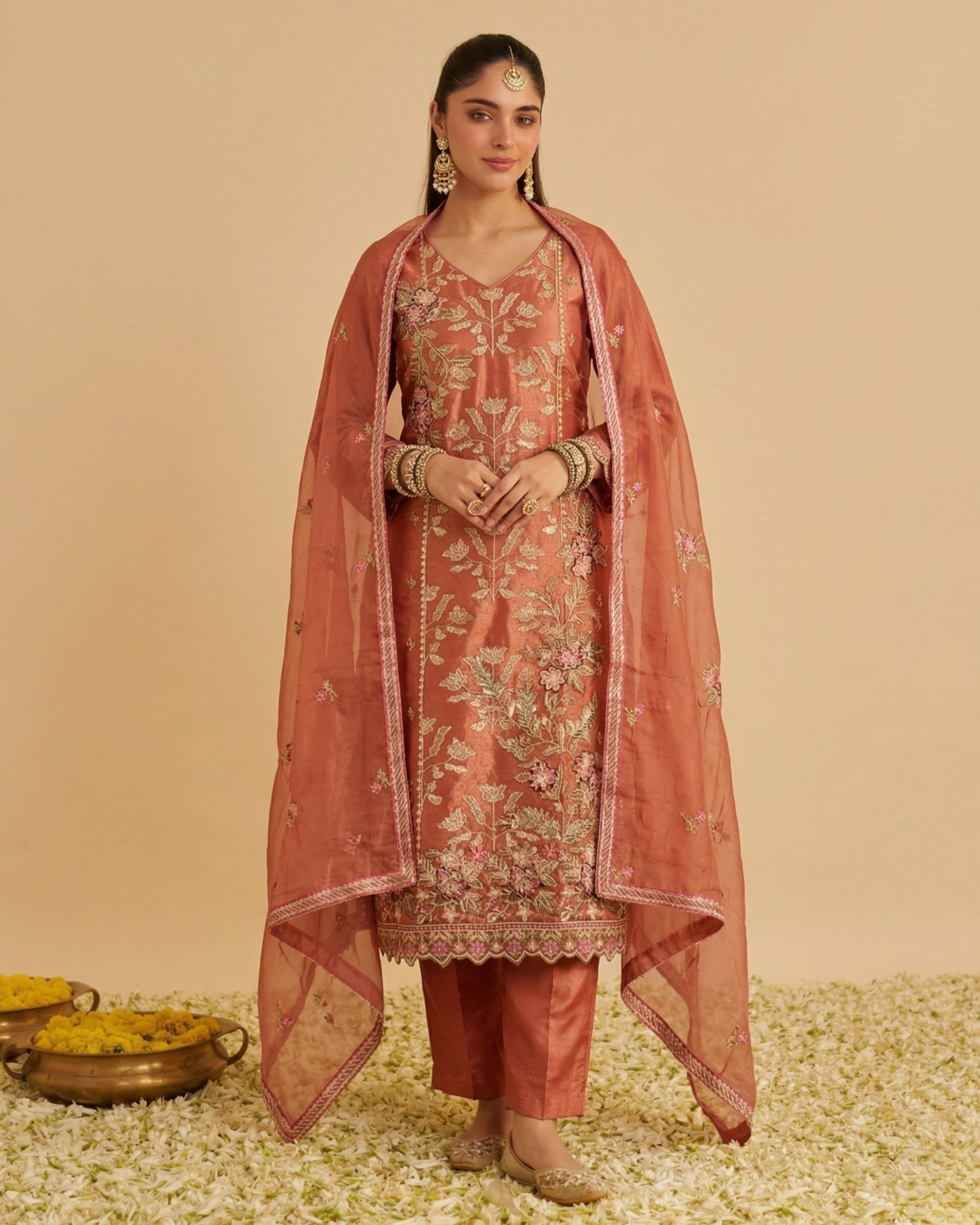 Woman wearing a traditional outfit with a sheer dupatta on a beige background