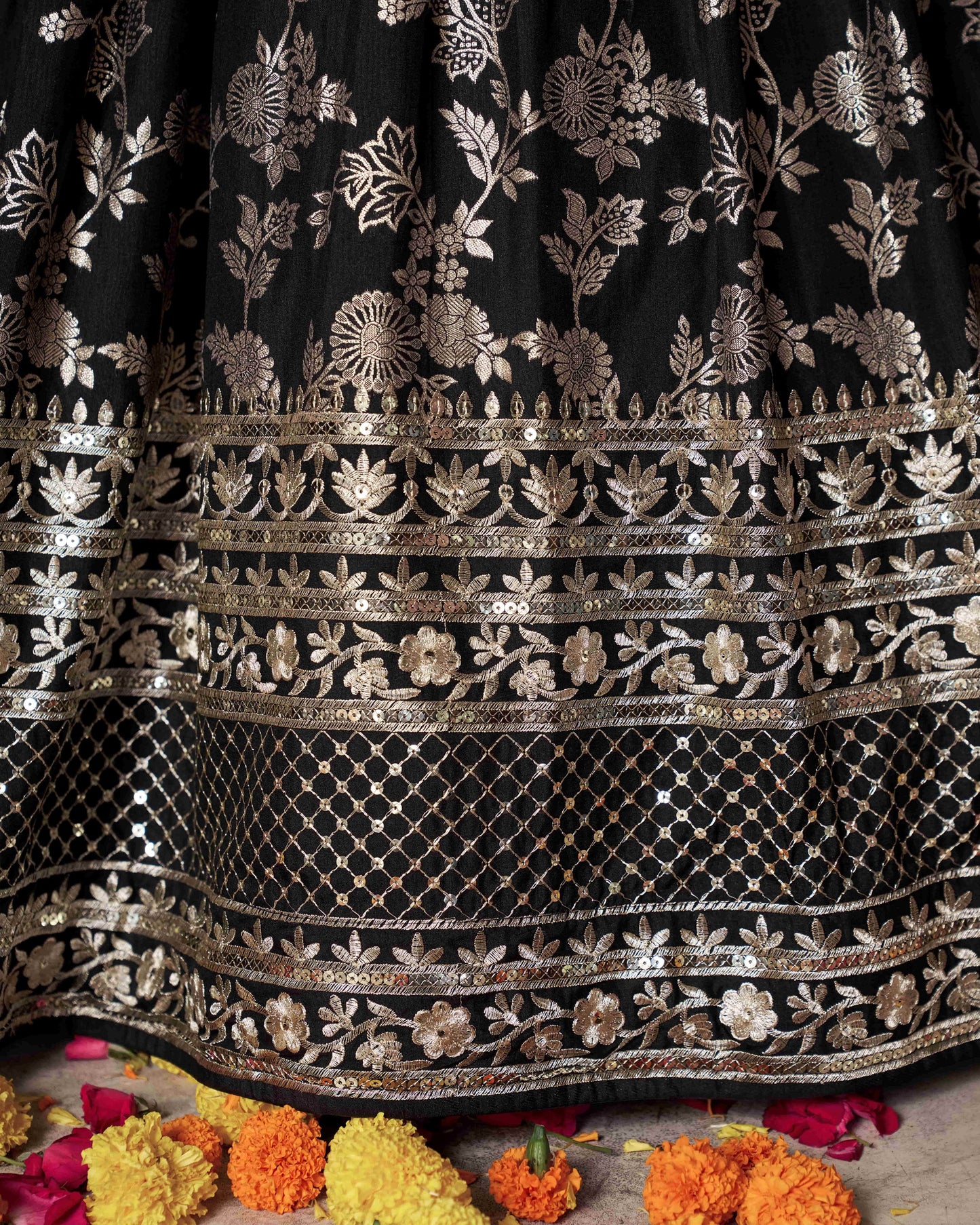 Black fabric with intricate gold embroidery on a floral background