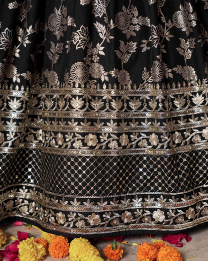 Black fabric with intricate gold embroidery on a floral background