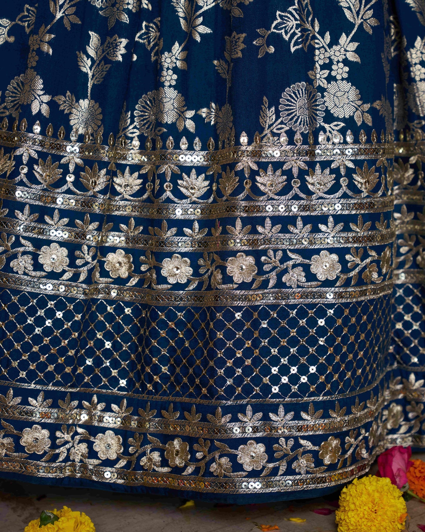 Close-up of a blue embroidered fabric with silver floral patterns