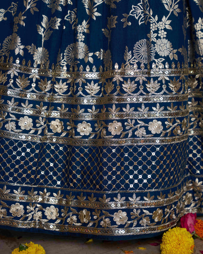 Close-up of a blue embroidered fabric with silver floral patterns