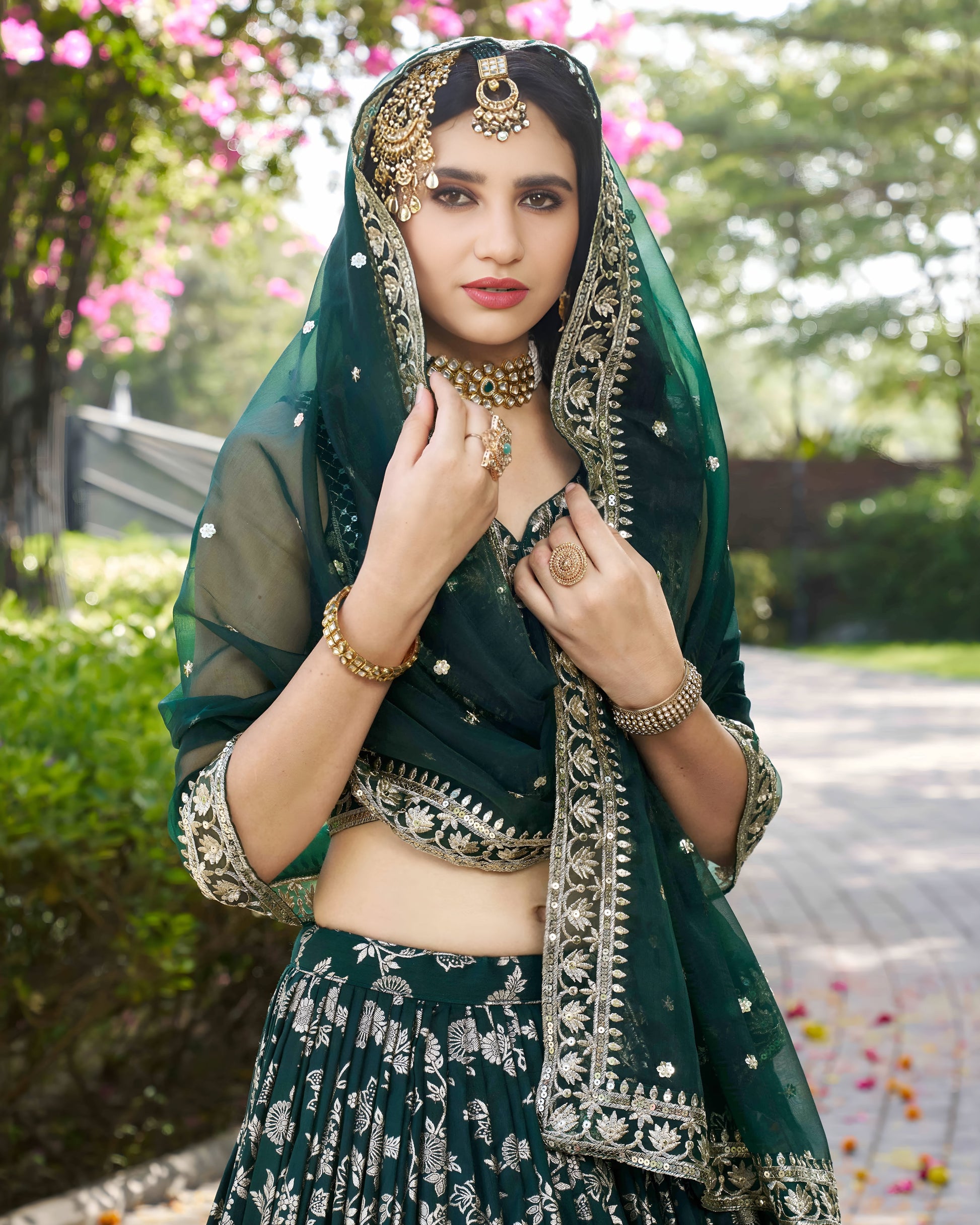Woman in traditional green outfit with jewelry outdoors