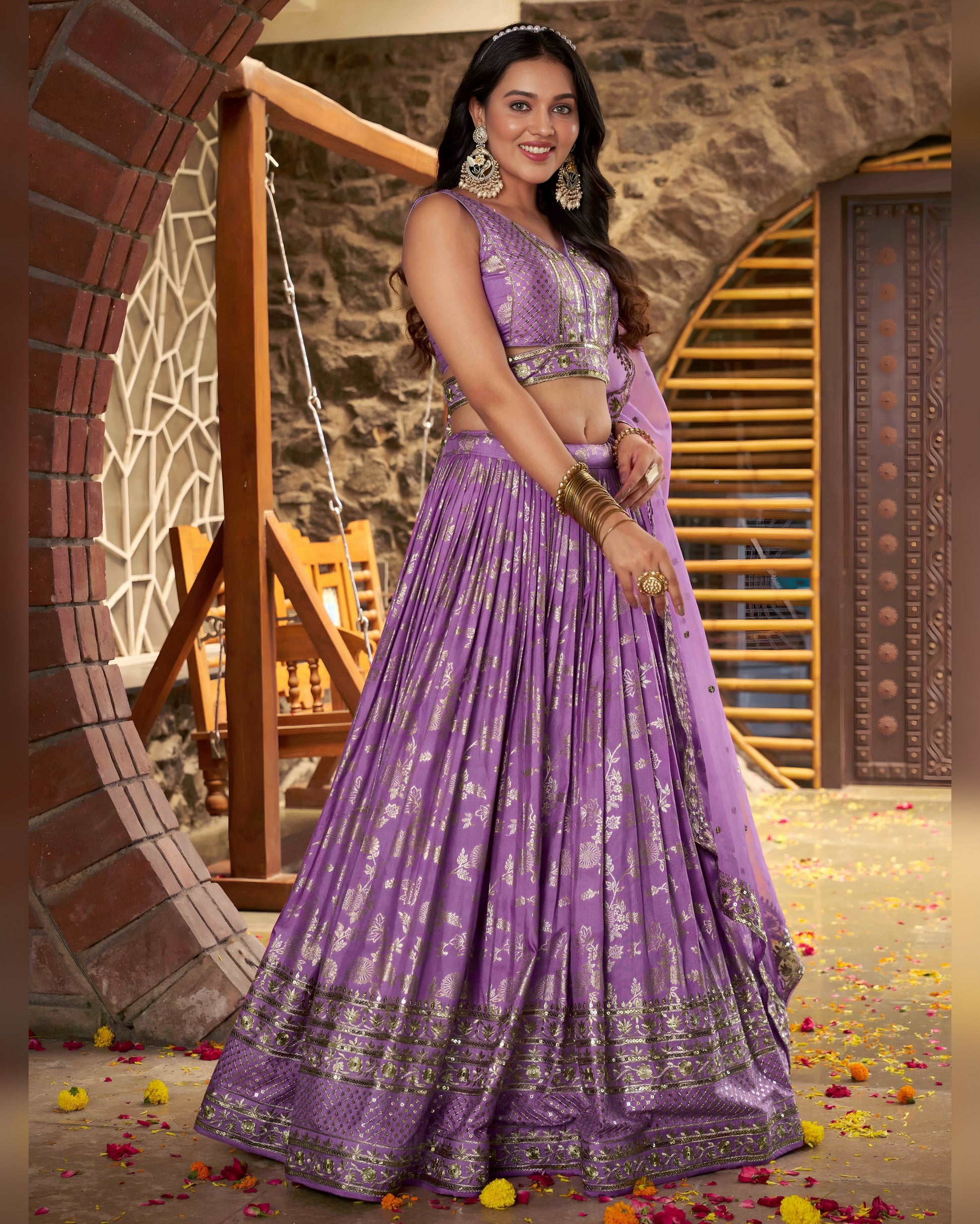 Woman in a purple traditional outfit standing in front of a decorative archway.