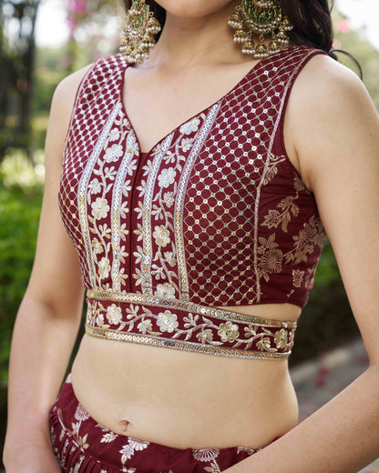 Maroon embroidered blouse with gold details worn by a person, outdoors.