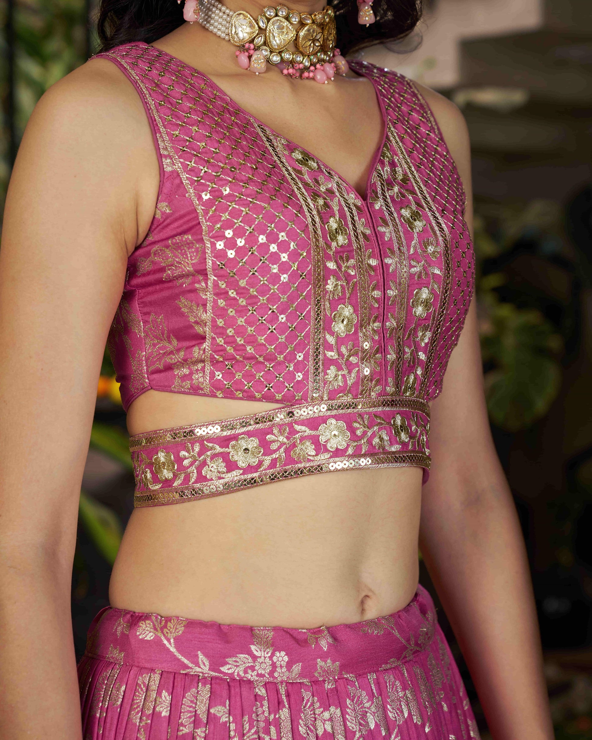 Pink embroidered blouse with intricate designs on a blurred background