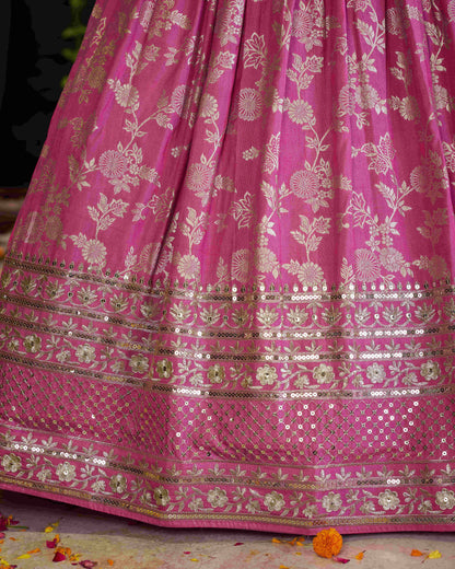 Pink saree with floral patterns and sequins on a dark background