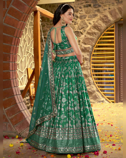Woman in a green traditional outfit standing in front of a stone wall with decorative elements.