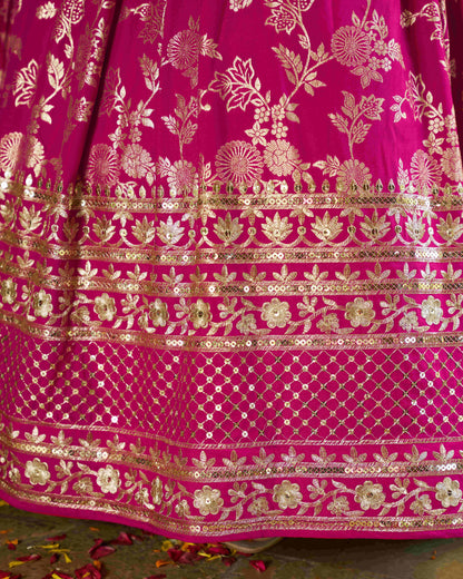Close-up of a pink fabric with gold floral patterns