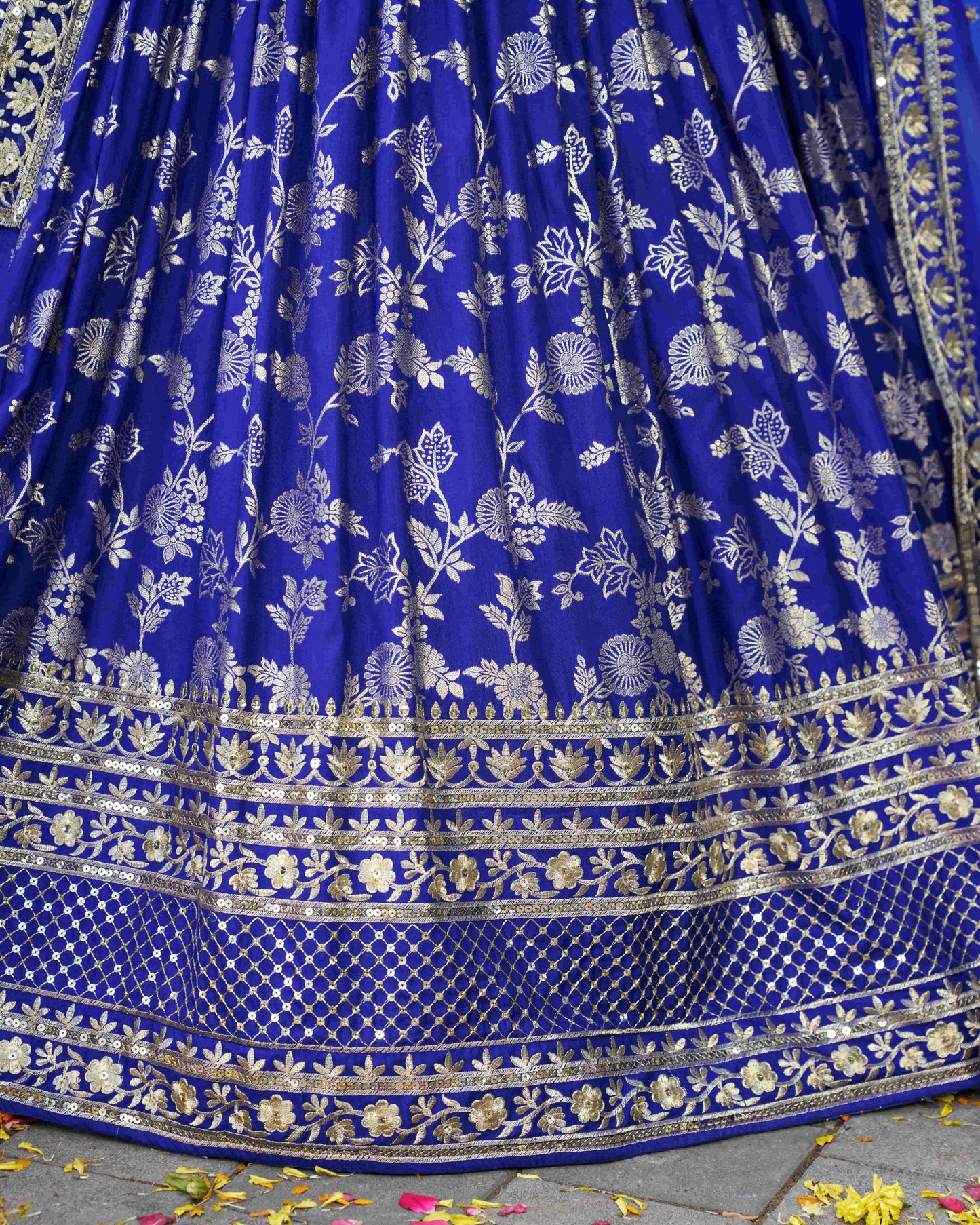 Blue fabric with white floral patterns and gold accents on a stone surface.