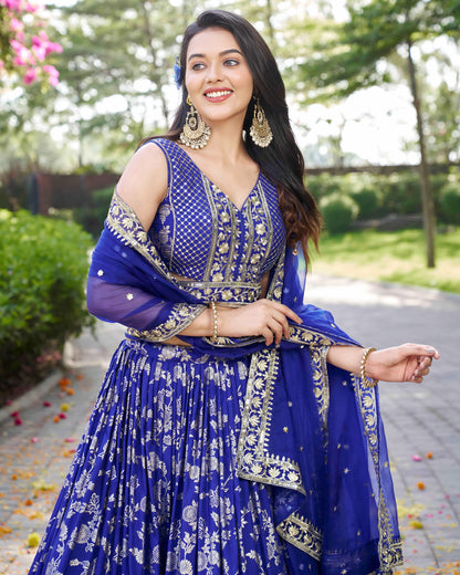 Woman in a blue traditional outfit with floral patterns outdoors.