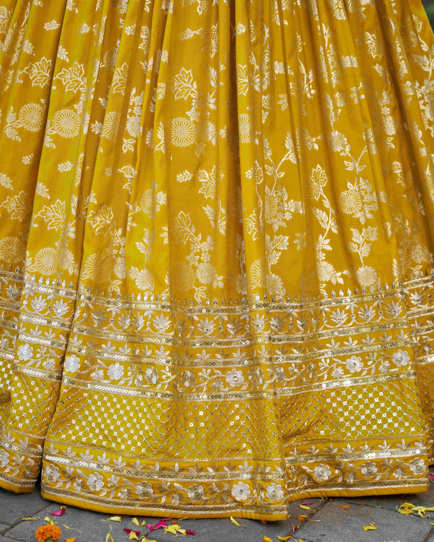 Yellow saree with floral patterns on a textured surface
