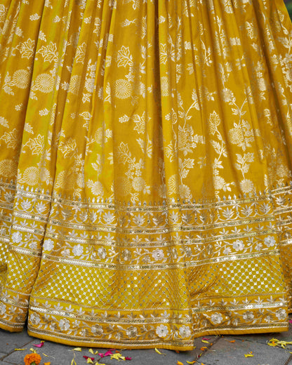 Yellow saree with floral patterns on a textured surface
