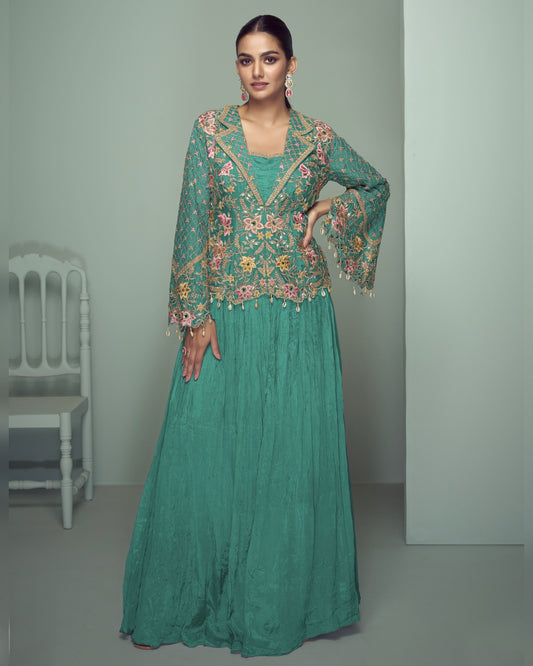 Woman wearing a green embroidered traditional outfit in a minimalistic setting