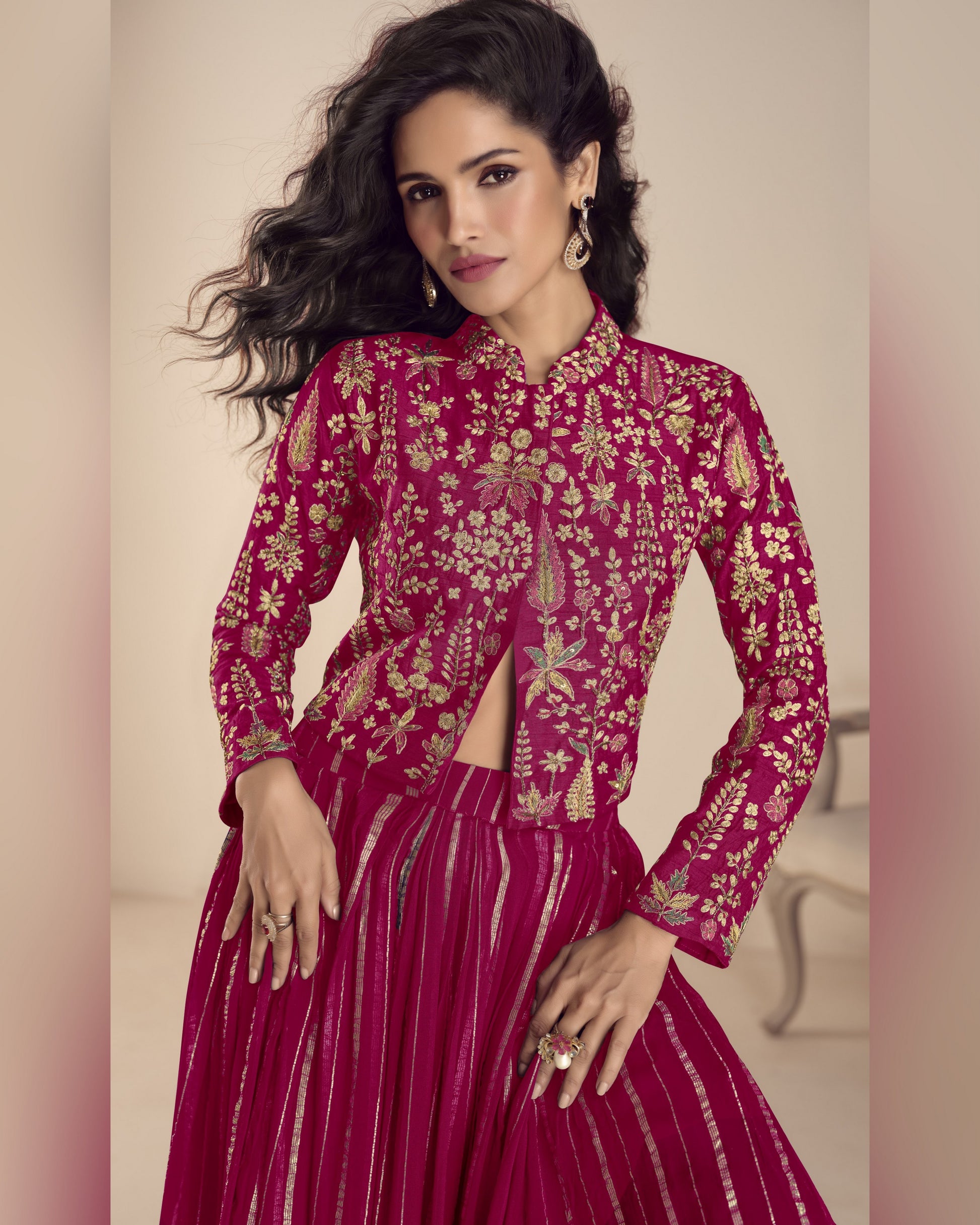 Woman wearing a pink embroidered traditional outfit with a neutral background