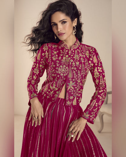 Woman wearing a pink embroidered traditional outfit with a neutral background