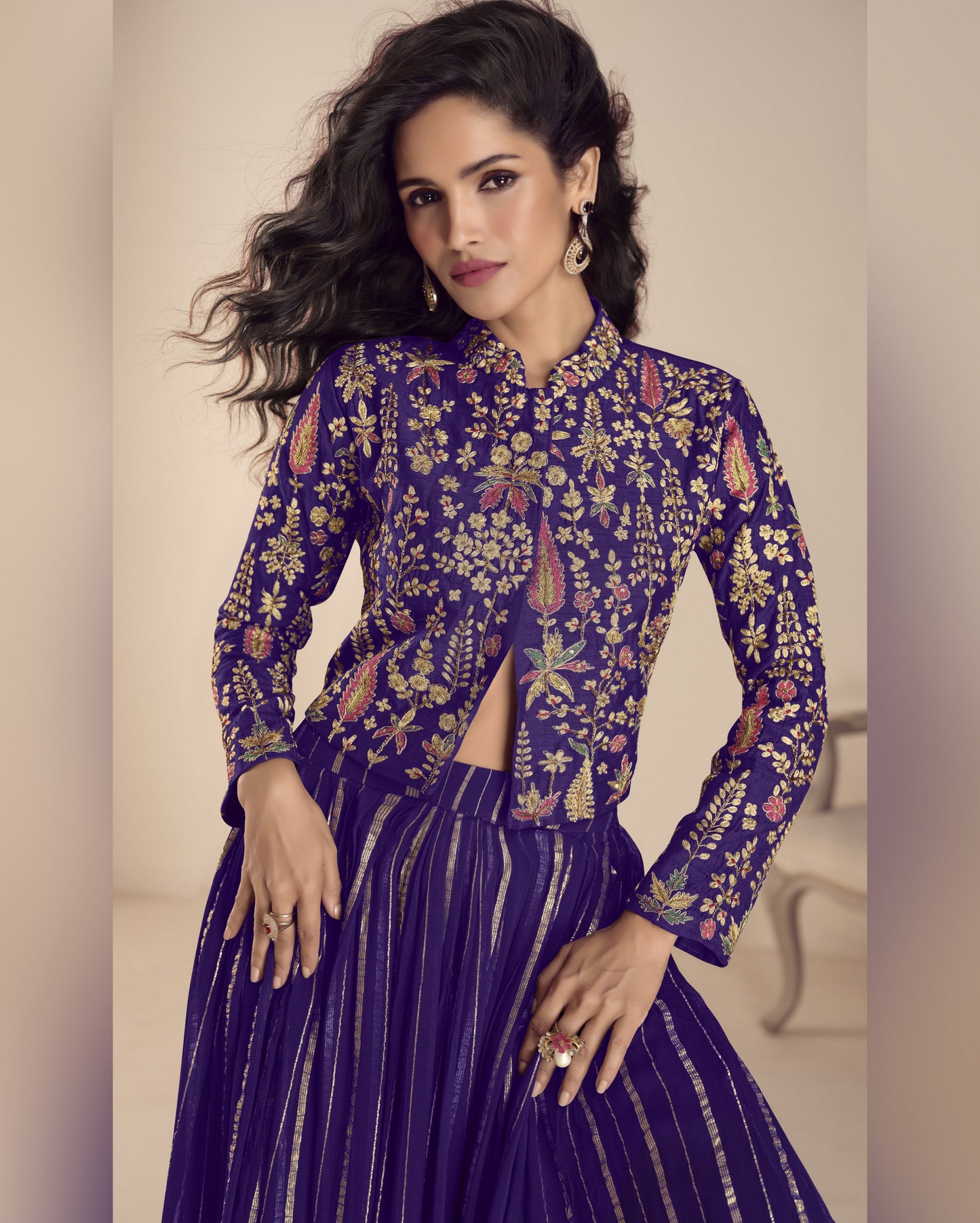 Woman wearing a purple embroidered outfit with a neutral background