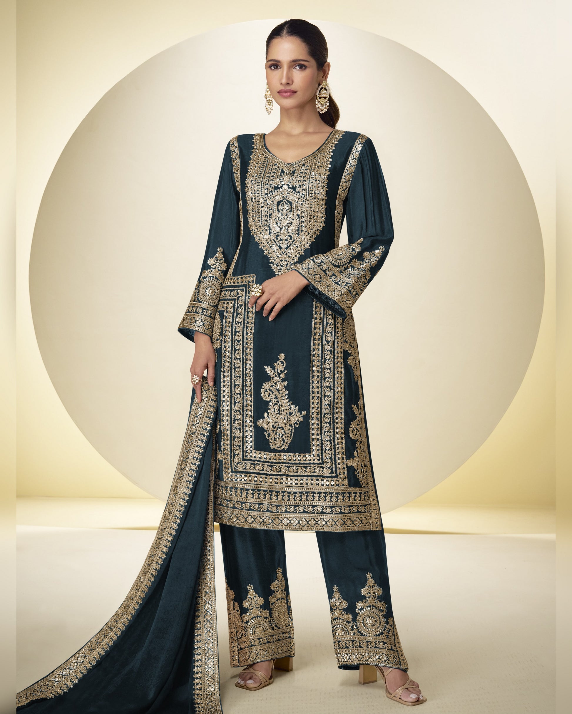 Woman wearing a dark blue embroidered traditional outfit with a beige background