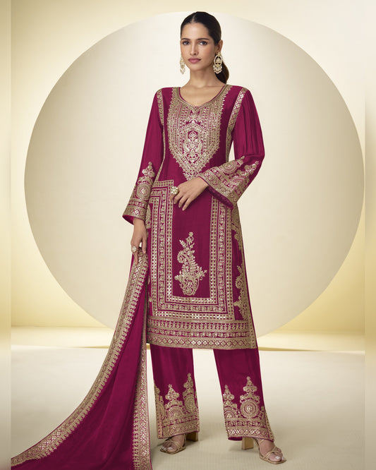 Woman wearing a magenta embroidered traditional outfit with a white background