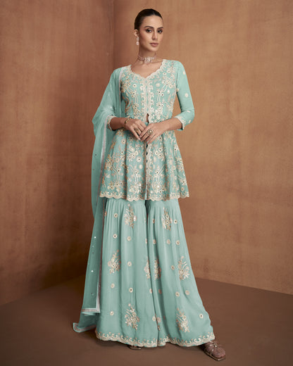Woman wearing a light blue embroidered traditional outfit against a brown background