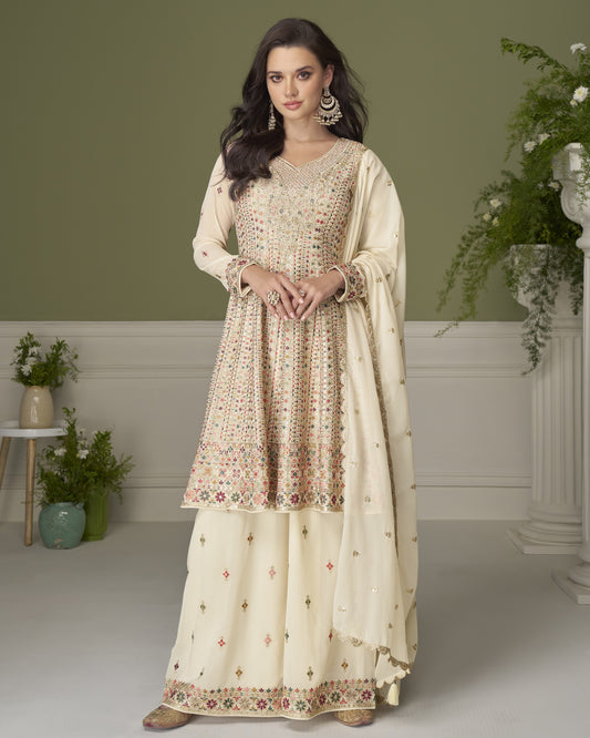 Woman wearing a traditional outfit with floral patterns in a well-lit room.