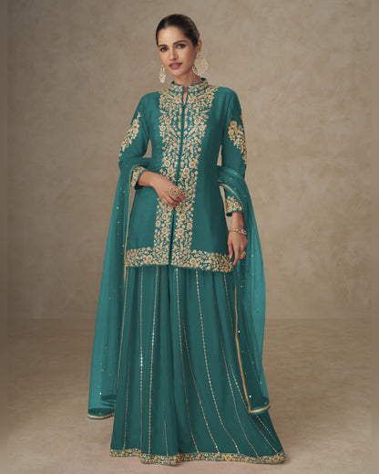 Teal traditional outfit with gold embroidery on a neutral background