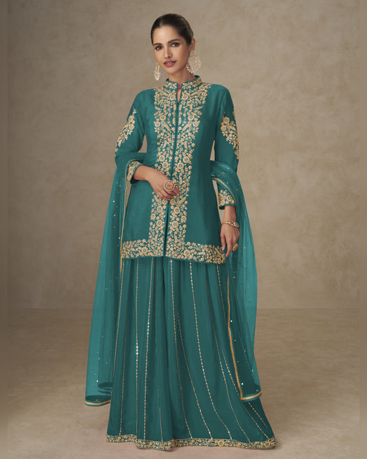 Teal traditional outfit with gold embroidery on a neutral background